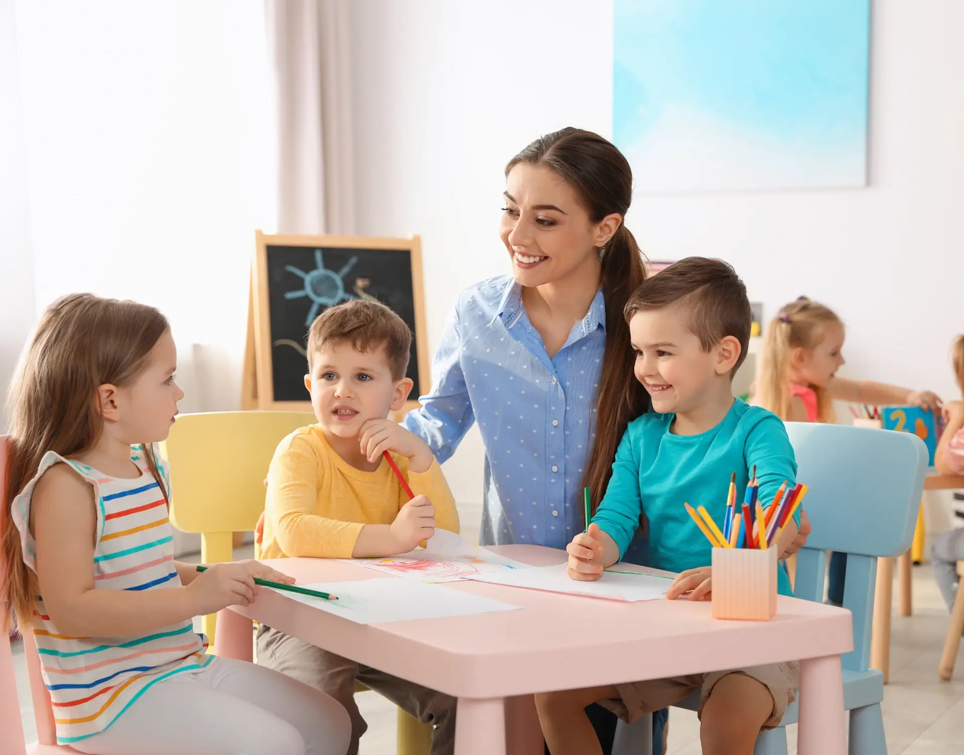 Frau mit Kindern sitzend im Kindergarten